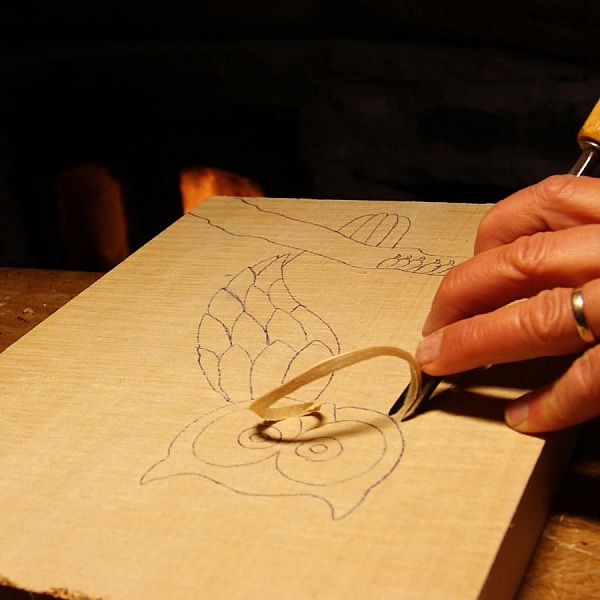Sculpture sur bois d'un hibou avec une gouge.