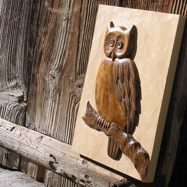 Sculpture en bois représentant un hibou sur une branche.
