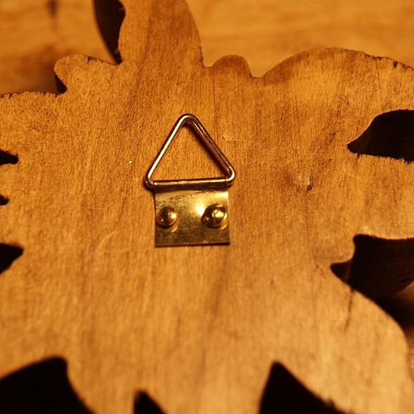 Attache triangulaire fixée au dos d'une décoration en bois.